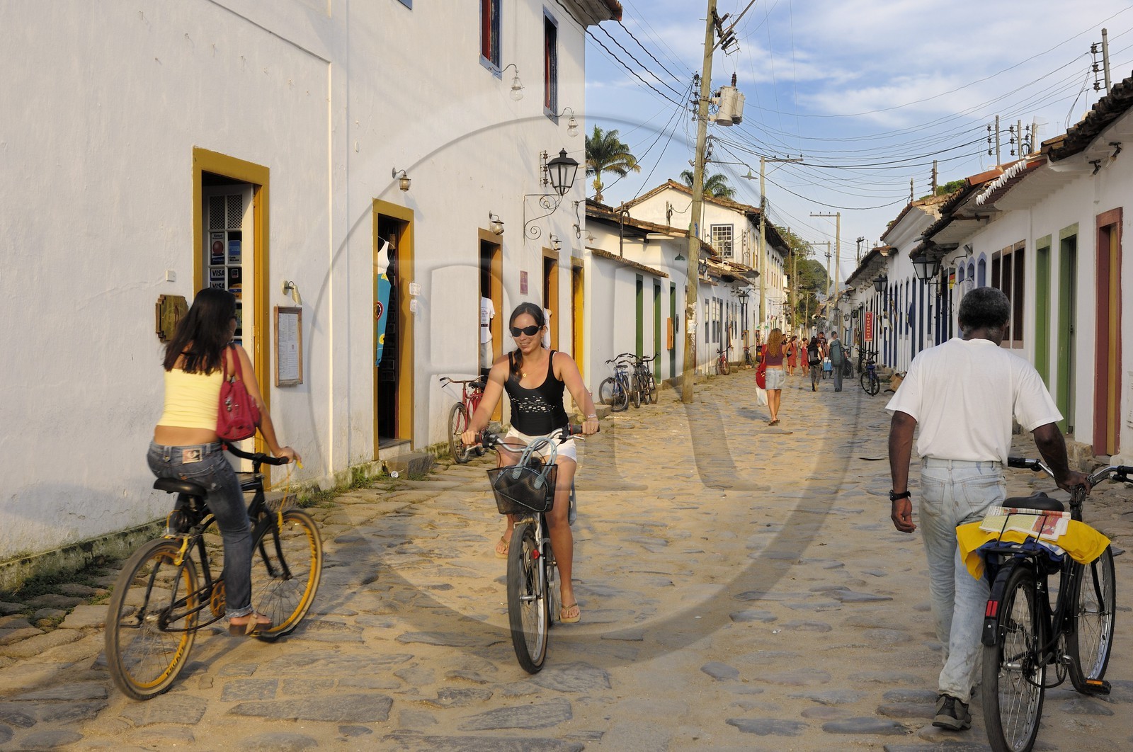 Brazil, Rio de Janeiro State, Paraty, colonial town founded in 1667 to export gold to Europe, cyclists in paved streets (Gold Route, Estrada Real)