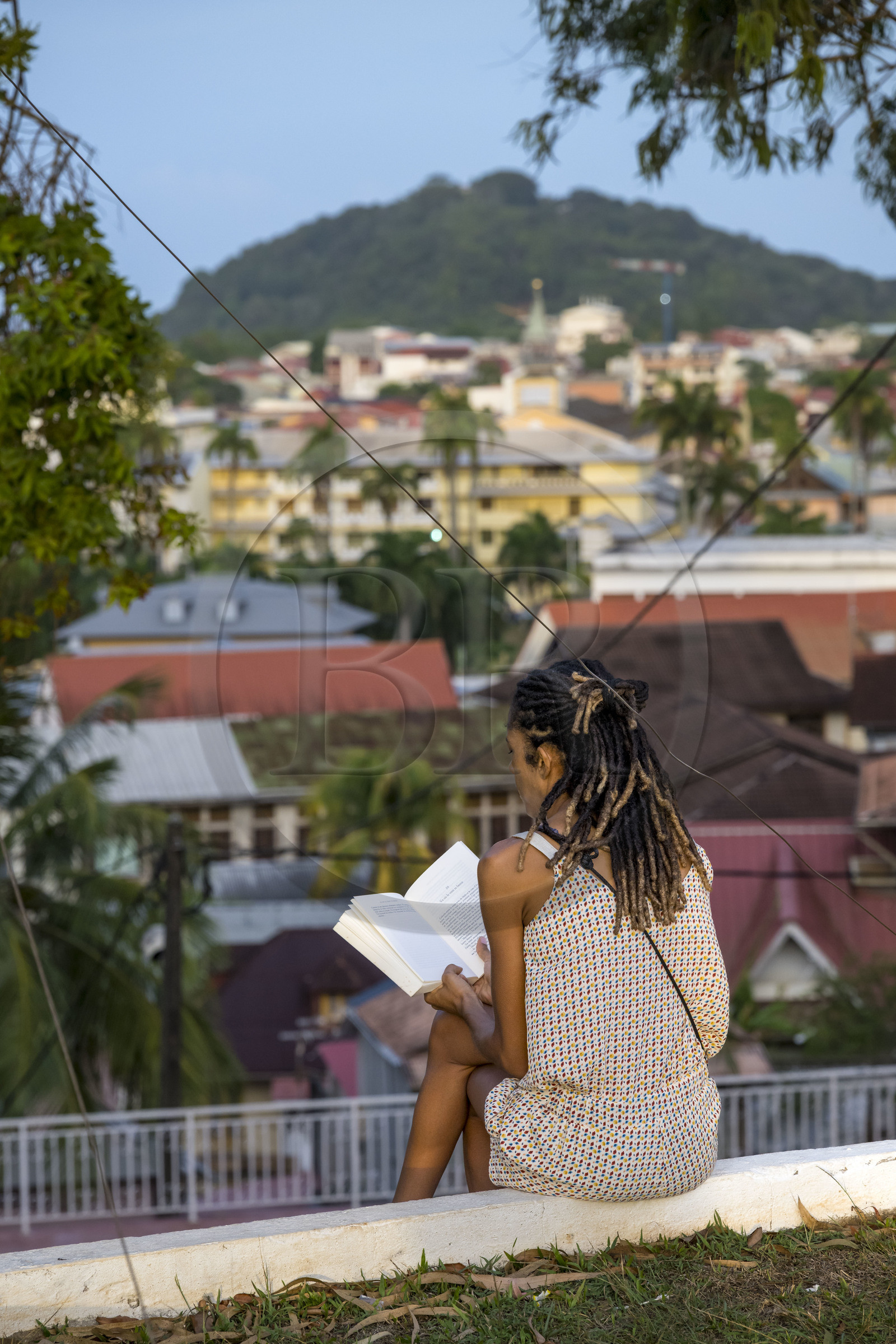 France, Guyane, Cayenne, fort Cépérou, femme y lisant un livre en fin de journée pour profiter de la vue