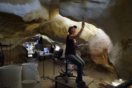 France, Dordogne (24), Montignac, chantier du futur Centre International de l'Art pariétal de Montignac-Lascaux (Lascaux 4), l'abside de la grotte reconstituée par l’Atelier des Fac-Similés du Périgord (AFSP) et le passage en arrière plan, réalisation des jointures des panneaux de surfaces ornées par la peintre Catherine Gout