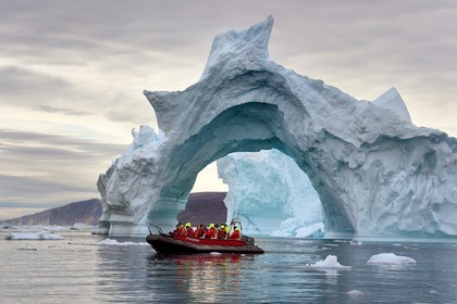 Groenland, cote Nord-Ouest, mer de Baffin, Inglefield Fjord vers Qaanaaq, iceberg formant un arche et un PolarCirkel boat (zodiac) d'exploration du bateau de croisière MS Fram de la compagnie Hurtigruten