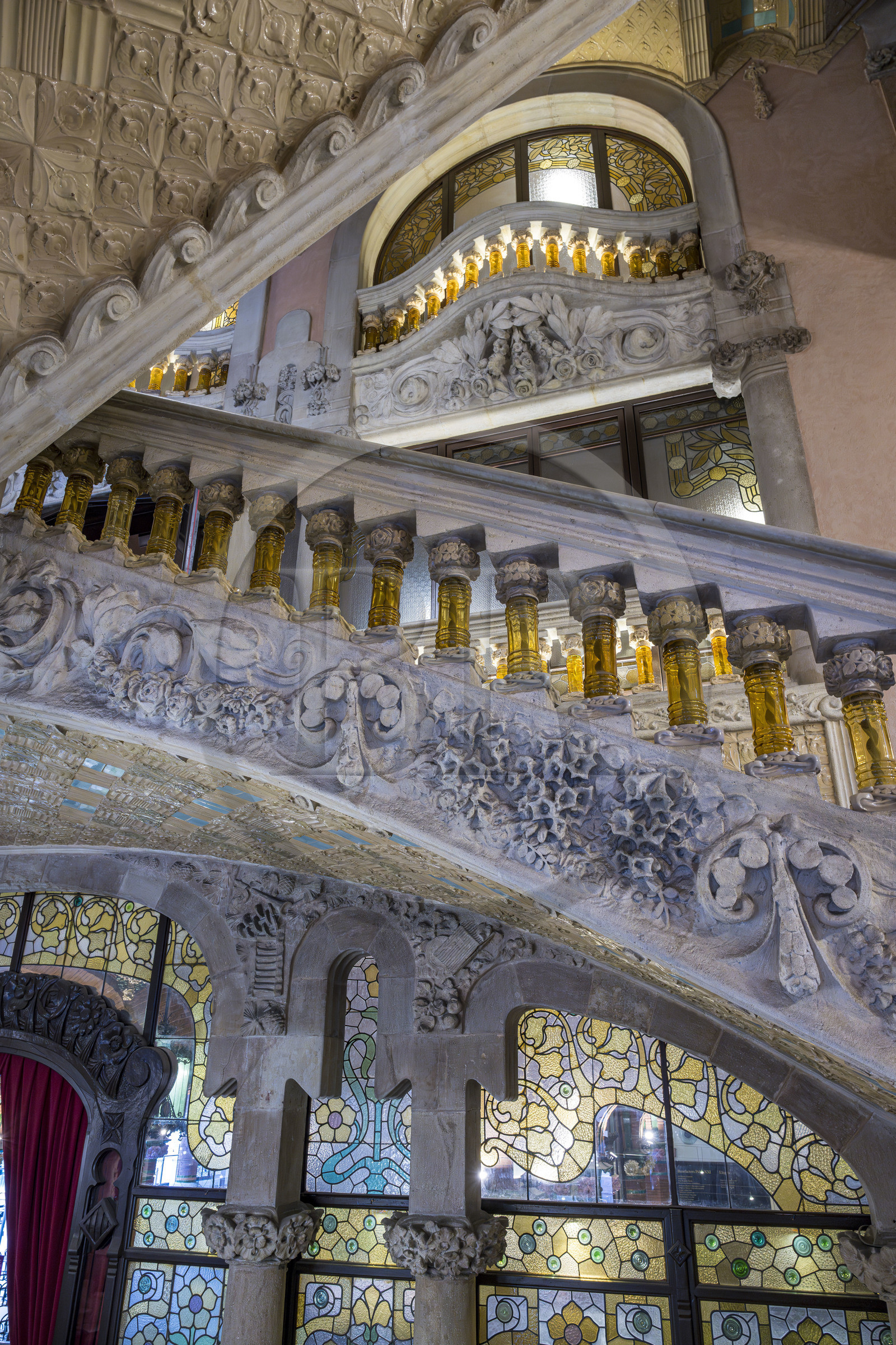 Espagne, Catalogne, Barcelone, Palau de la Musica Catalana (palais de la musique catalane), salle de concert dessinée par l'architecte du modernisme catalan Lluis Domènech i Montaner, site classé au Patrimoine Mondial de l'UNESCO, vestibule, la rampe des escaliers en pierre finement travaillée et supportée par des balustres en verre jaune transparent