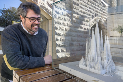 Spain, Catalonia, Barcelona, Eixample district, Sagrada Familia basilica by Catalan modernist architect Antoni Gaudi, listed as a UNESCO World Heritage Site, Xisco Llabrès, the architect in charge of the cloister construction site, in front of the model which presents the completed cloister under the facade of the apse