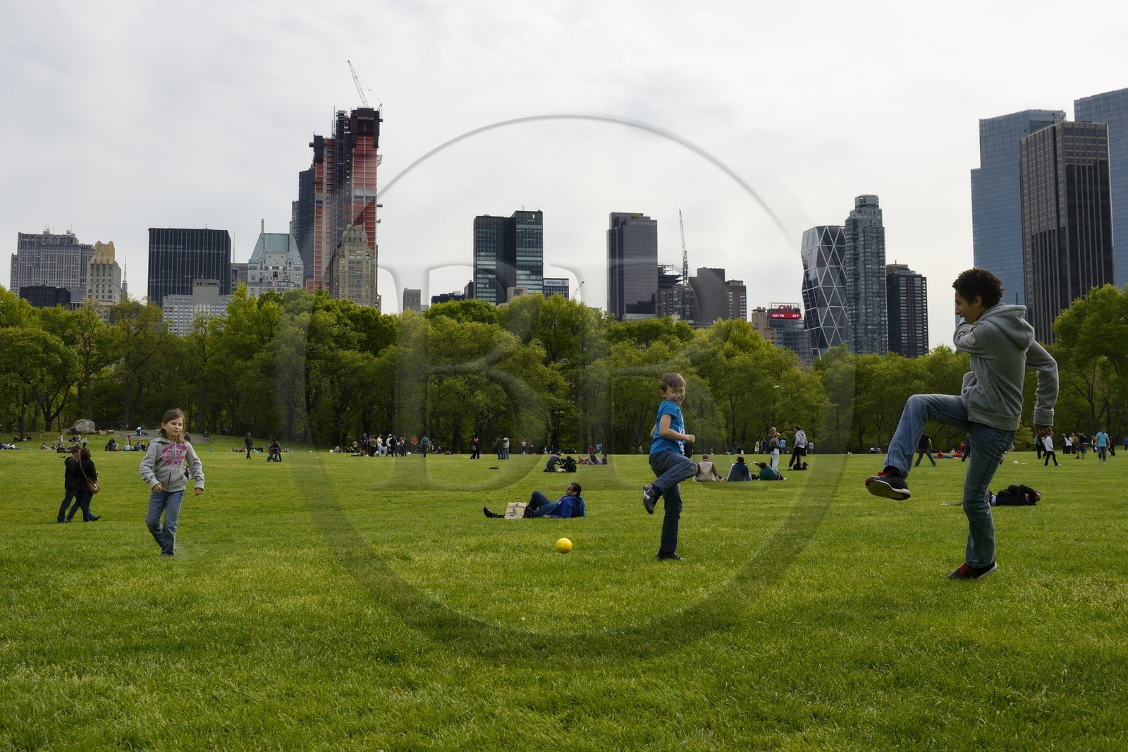 Etats-Unis, New York, Manhattan, Central Park, enfants jouant au football sur le Sheep Meadow, immeubles de Central Park Sud en arrière plan