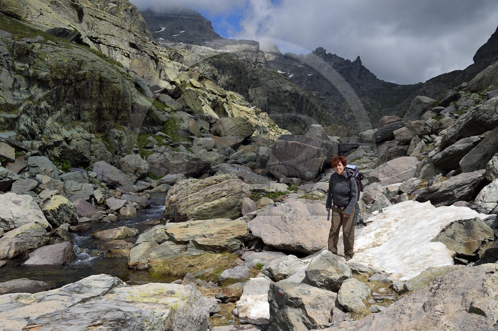 France, Alpes-Maritimes (06), parc national du Mercantour, Vallée des Merveilles parsemée de milliers de gravures rupestres de l'Age de bronze, l'archéologue Nicoletta Bianchi sur le sentier de randonnée GR 52 vers la Baisse de Valmasque et le Mont du Grand Capelet (2915m) en arrière plan