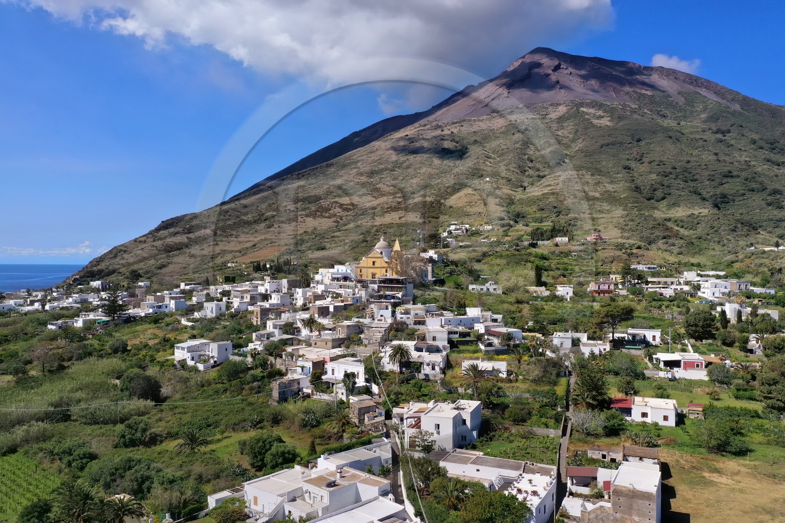 Italie, Sicile, iles Eoliennes, classées Patrimoine Mondial de l'UNESCO, ile de Stromboli, le village dominé par le volcan actif du Stromboli en arrière plan (vue aérienne)