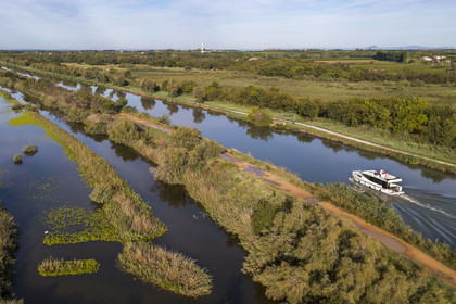 France, Gard (30), la Petite Camargue, navigation d'un bateau de plaisance Le Boat sur le canal du Rhône à Sète entre Gallician et Aigues-Mortes (vue aérienne) France, Gard, the Petite Camargue, navigation of a pleasure boat Le Boat on the Rhone to Sète Canal between Gallician and Aigues-Mortes (aerial view)