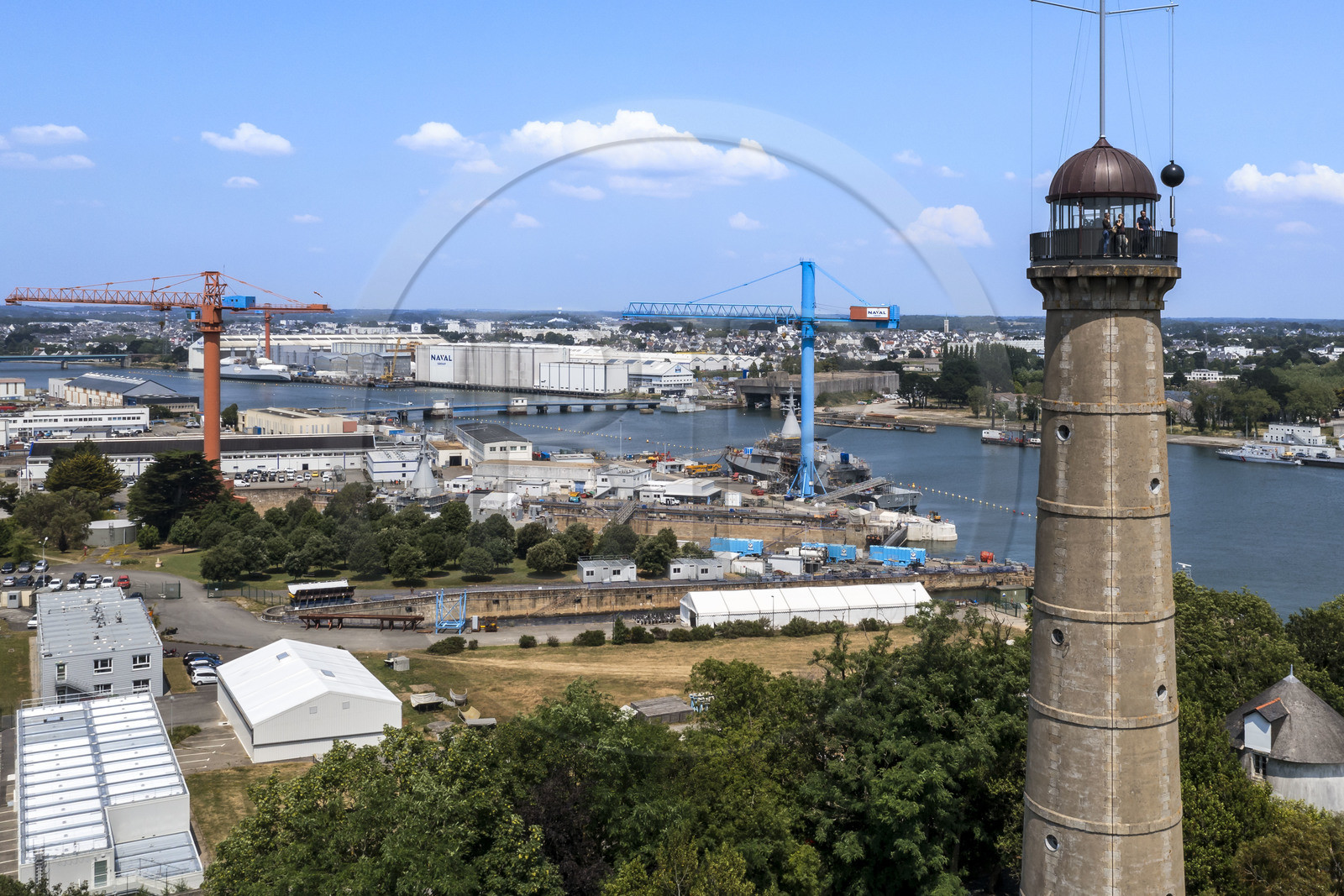 Morbihan (56), Lorient, l’Enclos du port, La tour de la découverte, la boule horaire donne chaque jour l’heure solaire de midi en chutant, et les installations de Naval Group en arrière plan (vue aérienne)