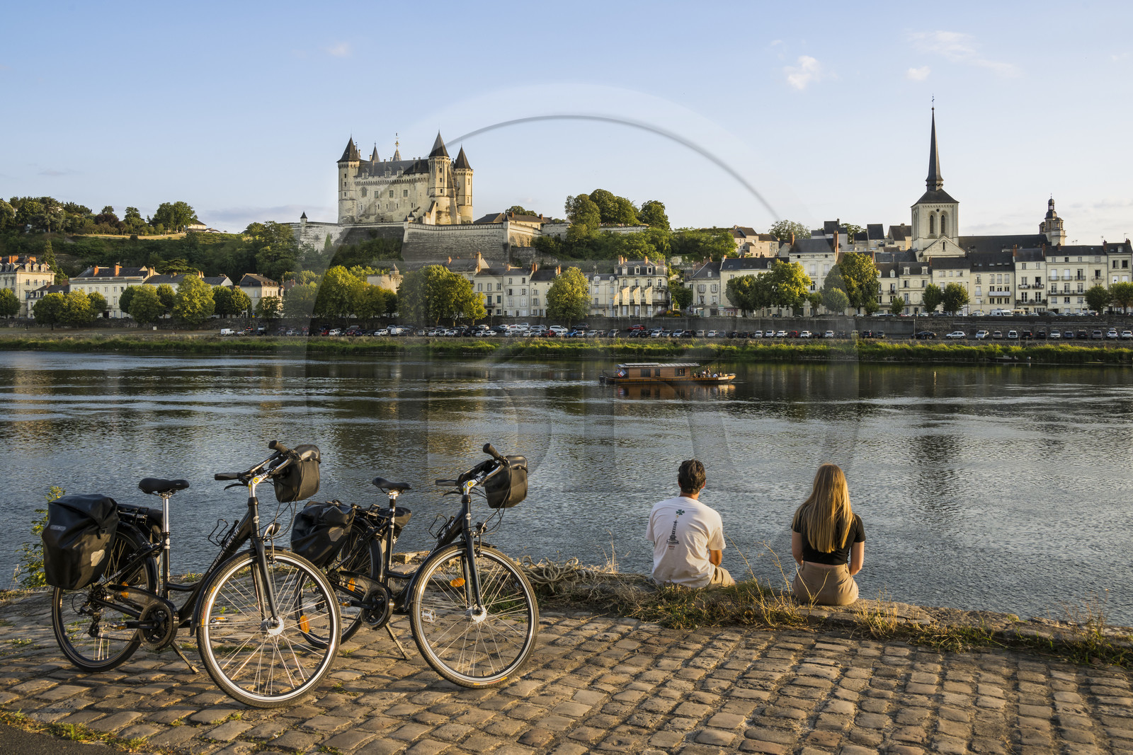 France, Maine-et-Loire, Loire valley listed as World Heritage by UNESCO, Saumur, cycling on the banks of the Loire, the castle and the church of Saint-Pierre on the banks of the Loire river