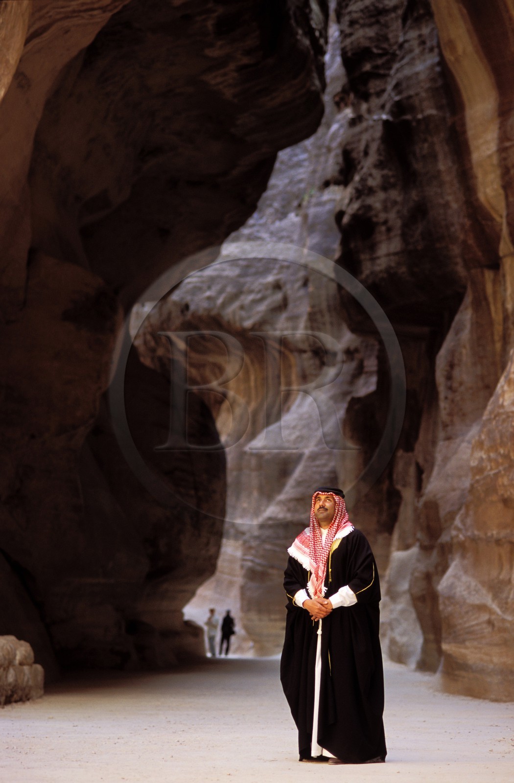 Jordan, Petra, Bedouin contemplating the sîq dug by Wadi Mousa river and leading to the Khazneh