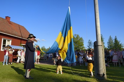 Suède, comté de Dalécarlie, région de Leksand, célébrations du solstice d'été dans le petit hameau de Hjulbäck, lever du drapeau suédois