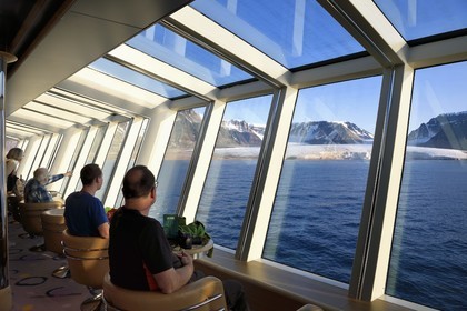 Greenland, North West coast, Murchison sound north of Baffin Bay, Hurtigruten's MS Fram cruise ship, passenger watching the Kissel Glacier on Kiatak (Northumberland Island) from the panoramic room