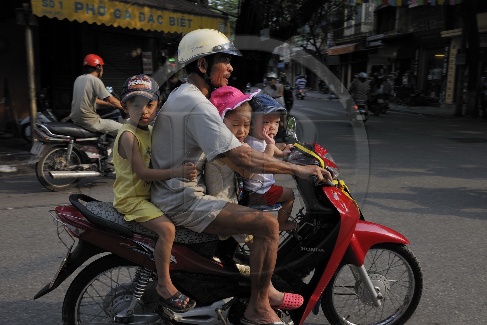 Vietnam, Hanoï, circulation d'une famille sans casque en moto dans la vieille ville