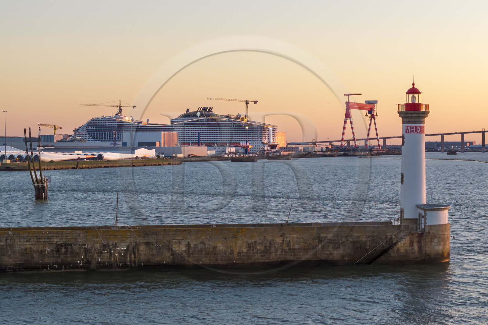 France, Loire-Atlantique, Saint-Nazaire, the Vieux Mole lighthouse and the 333m MSC World America cruise ship built by Chantiers de l'Atlantique in the background (aerial view)