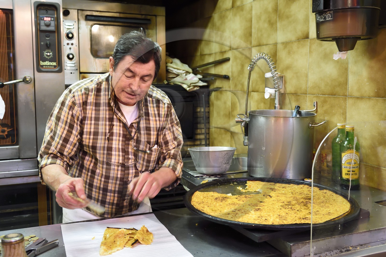 Principality of Monaco, Monaco, Condamine Market, Roger cutting socca parts in his shop