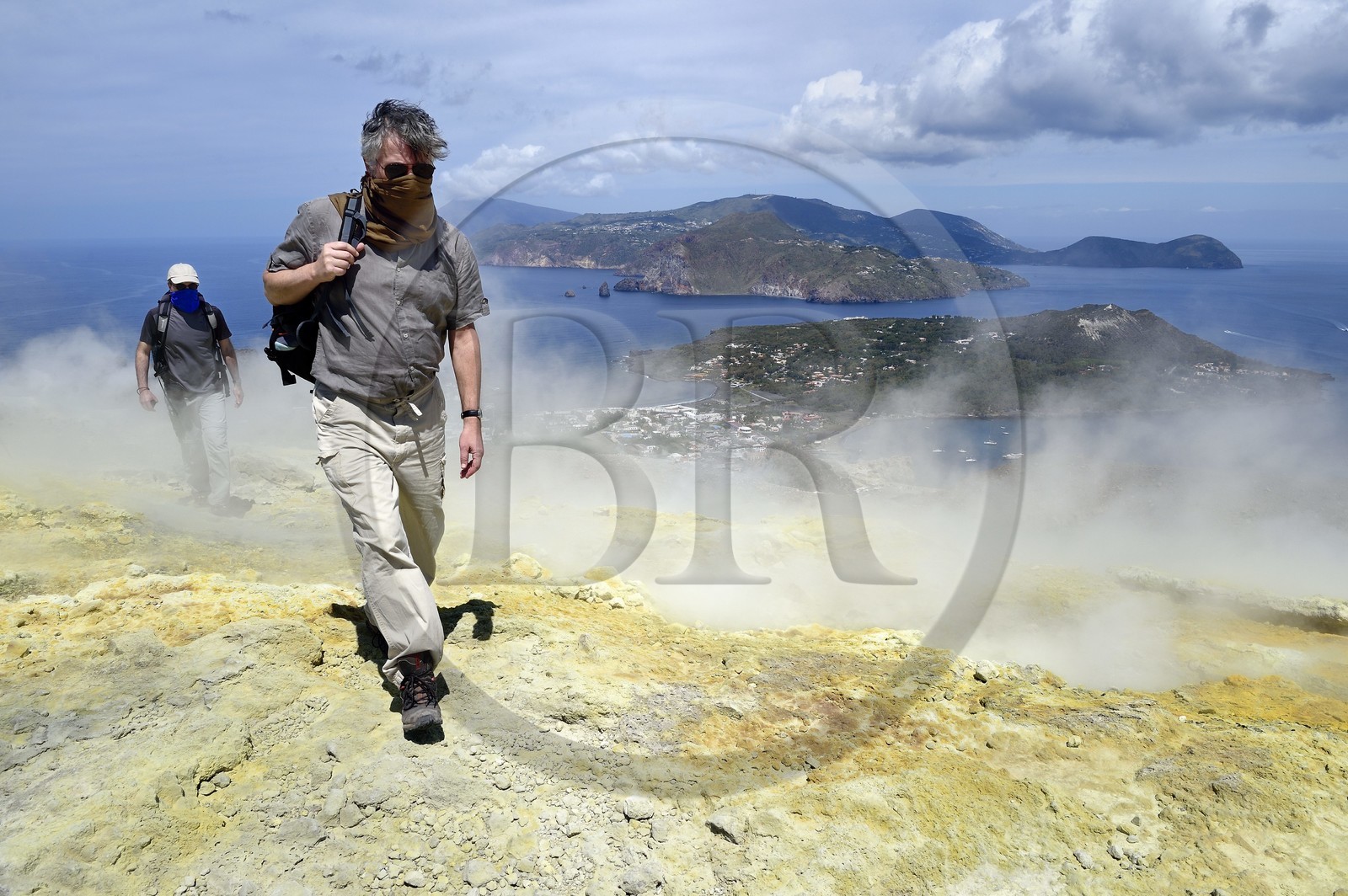 Italy, Sicily, Aeolian Islands, listed as World Heritage by UNESCO, Vulcano Island, hikers climbing the crater of volcano della Fossa through sulfur fumaroles, Lipari Island in the background