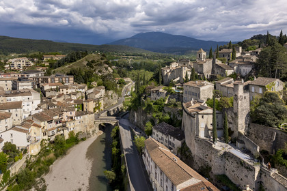France, Vaucluse, Vaison la Romaine, the Roman bridge over the Ouveze river dating from the 1st century AD which links the lower town and the medieval town on the right, the Mont Ventoux in the background (aerial view)