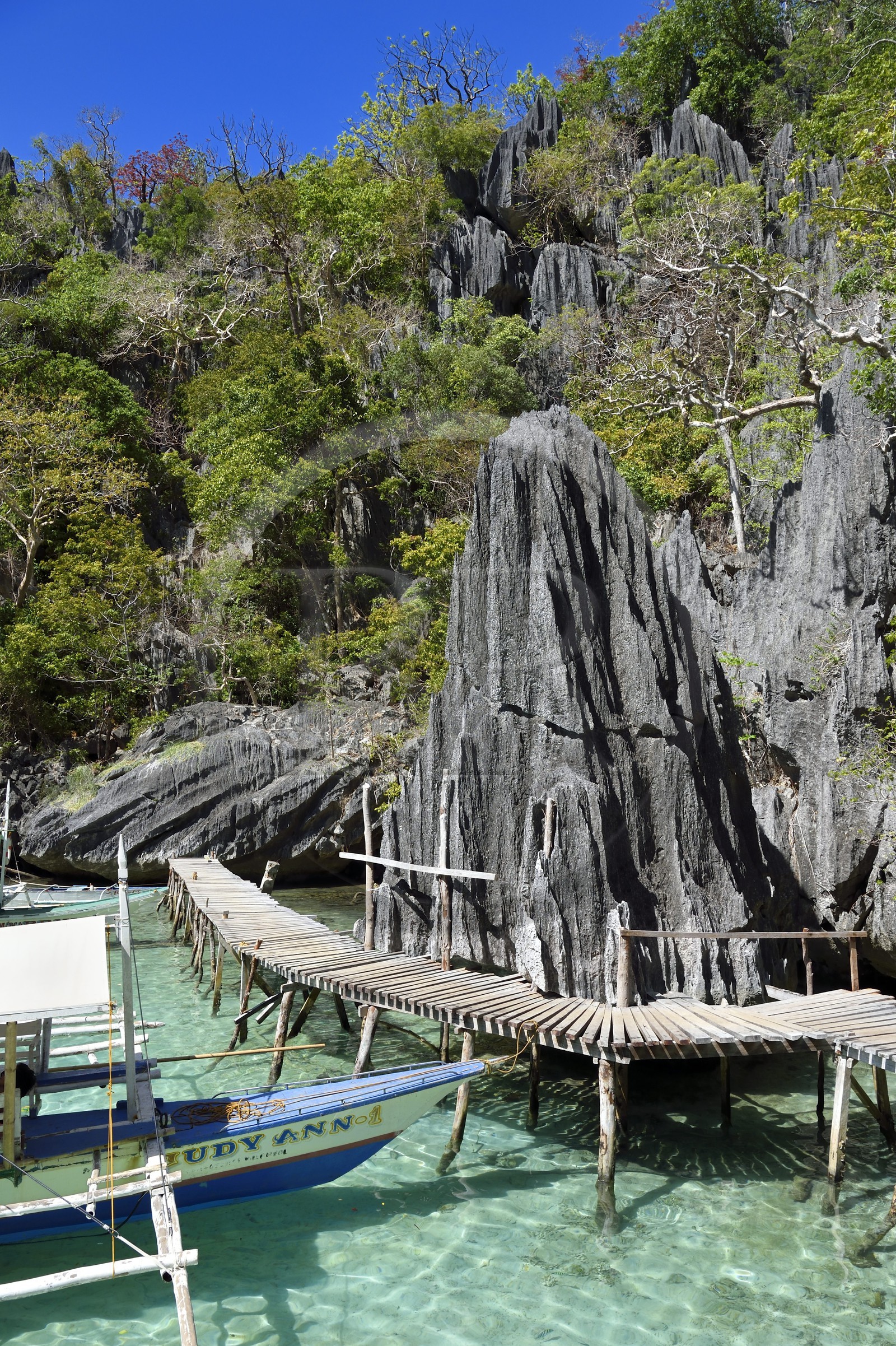 Philippines, Calamian Islands dans le nord de Palawan, Coron Island Natural Biotic Area, pirogue à balancier au pied des rochers de calcaire