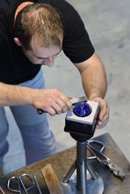 France, Moselle (57), Meisenthal, Centre international d’Art verrier (CIAV), l'atelier de soufflage, fabrication artisanale d'une boule de Noël, finalisation de la mise en place du crochet en verre