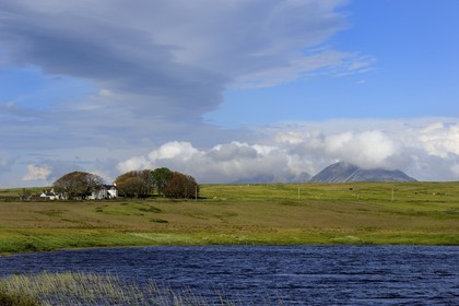 Royaume-Uni, Ecosse, Hébrides intérieures, Ile de Islay, maison en bordure du Loch Finlaggan et les montagnes de l'île de Jura en arrière plan