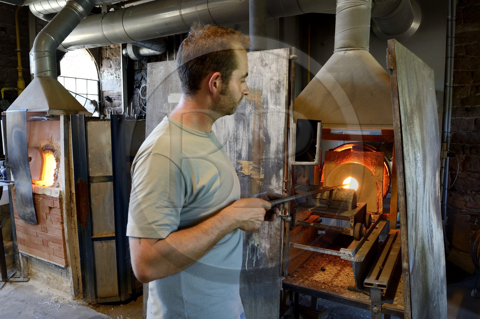 France, Moselle (57), Meisenthal, souffleur de verre au Centre international d'Art verrier (CIAV), récupération du verre chaud dans un four par un souffleur