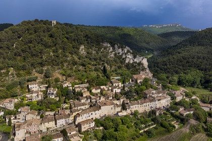 France, Vaucluse, Dentelles de Montmirail mountains, the medieval village of Séguret, labelled Les Plus Beaux Villages de France (The Most Beautiful Villages of France), on a stormy day and the Saint-Amand ridge seen from the south in the background (aerial view)