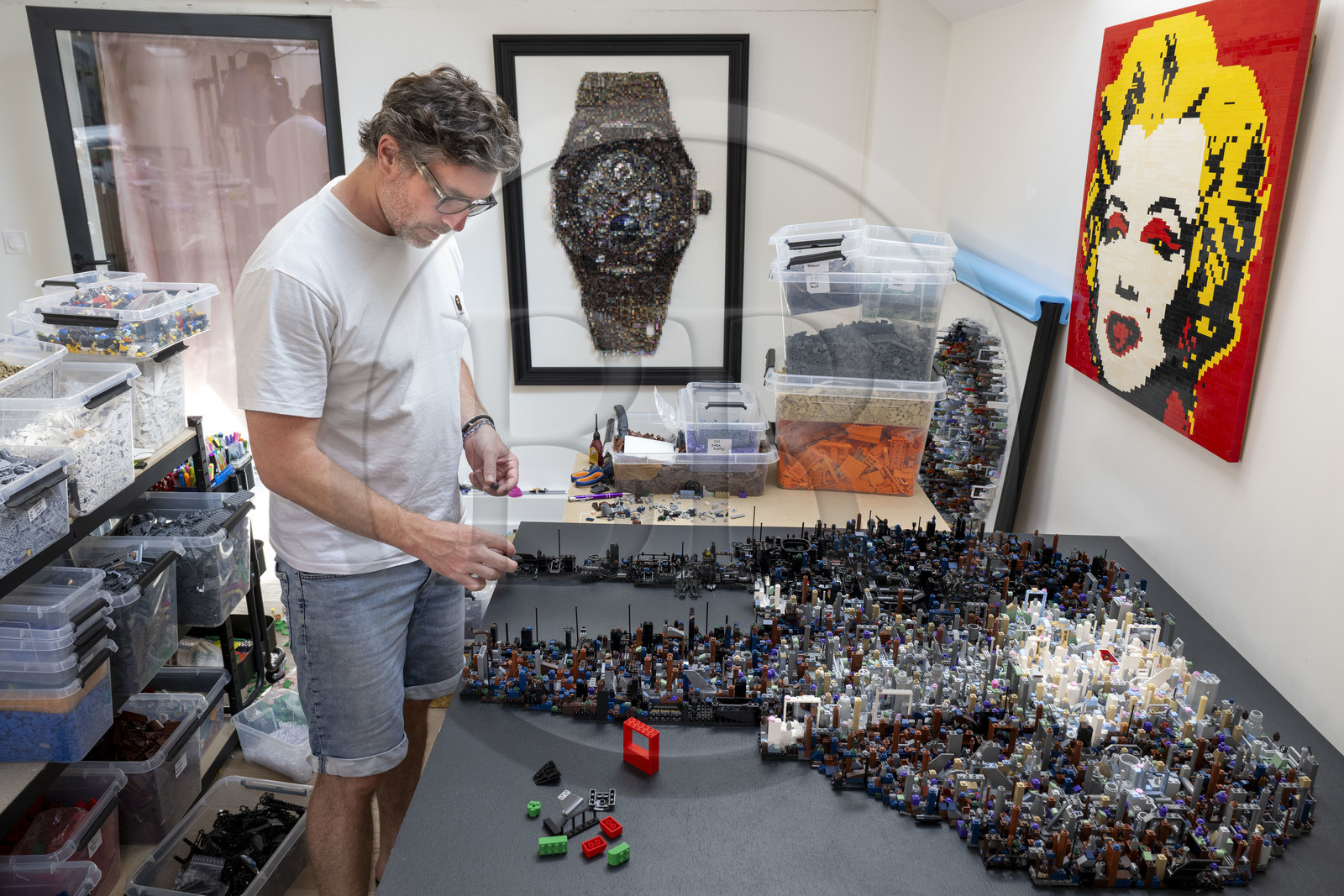 France, Cote d'Or, Dijon, Artist Aymeric Gillet, aka M'Brick, in his studio filled with crates of multicolored Lego used to create giant pixelated paintings inspired by pop culture
