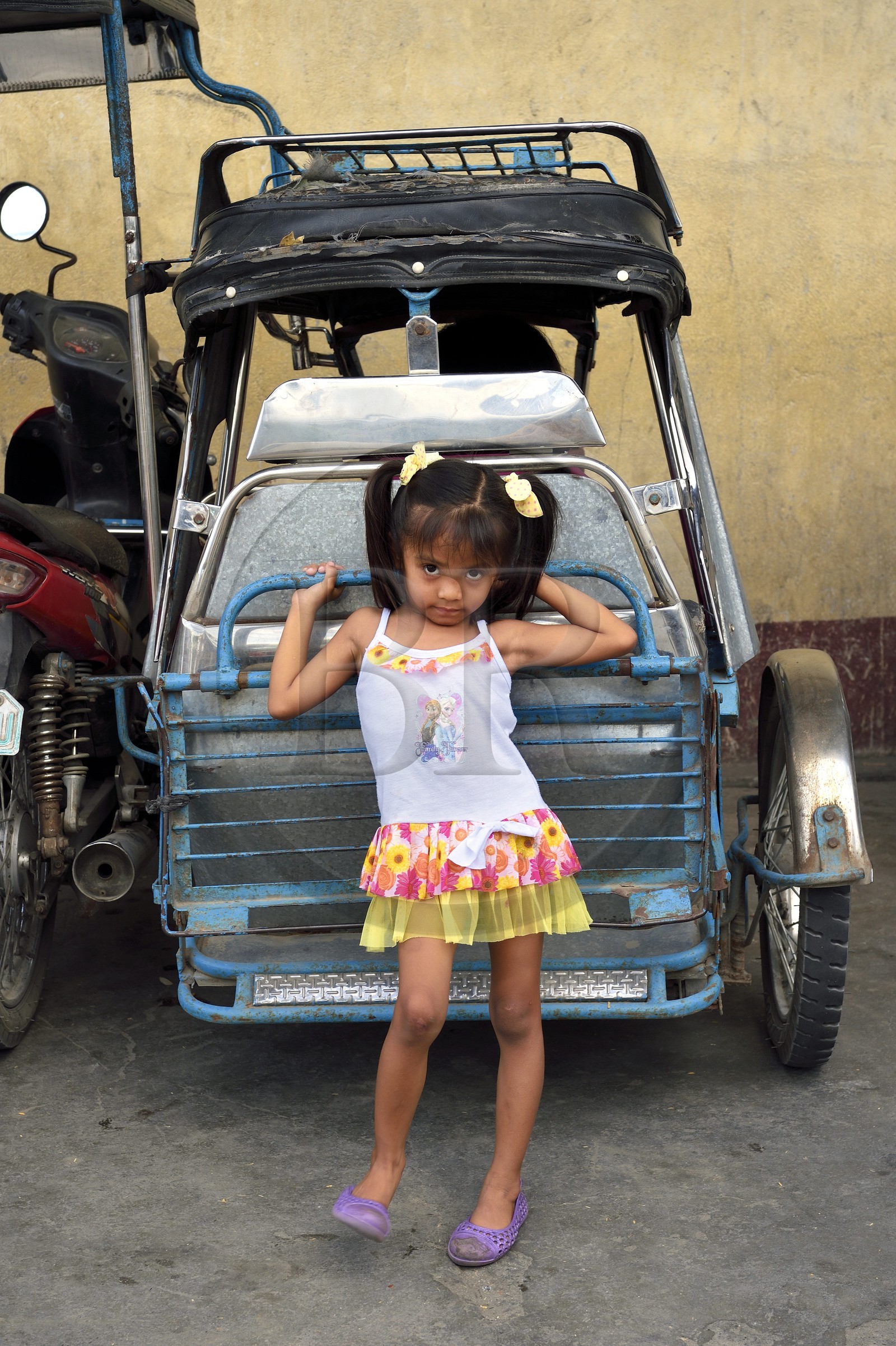 Philippines, province de Tarlac, Victoria, fillette devant un tricycle moto-taxi