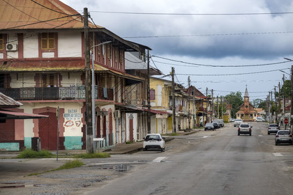 France, Guyane, Saint-Laurent-du-Maroni, maisons coloniales bordant l'avenue Felix Eboué dans la vieille ville et l'église de saint laurent du maroni en arrière plan