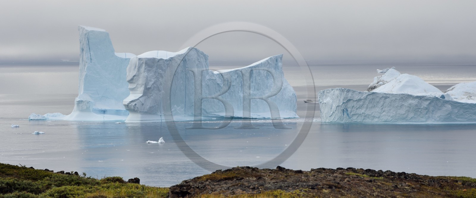 Groenland, cote ouest, Ile de Disko, Qeqertarsuaq, bateau entre deux icebergs le long de la côte
