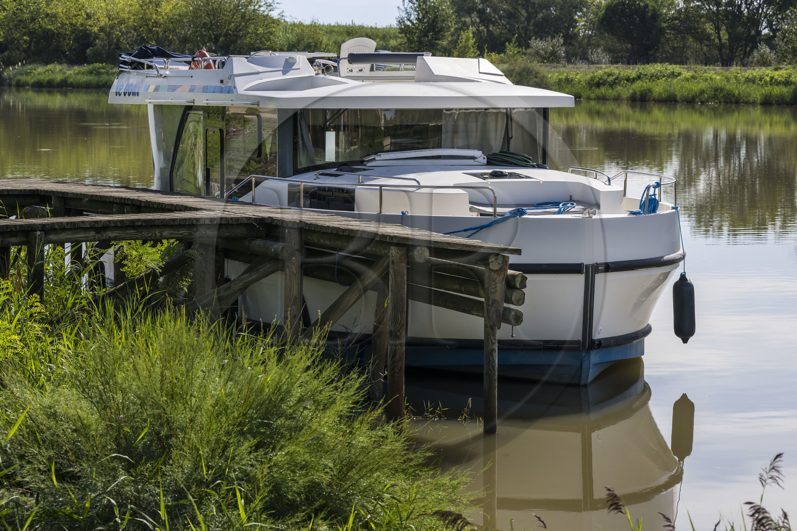 France, Gard, the Petite Camargue, Saint-Laurent-d'Aigouze, pleasure boat Le Boat moored to a wooden pontoon on the Canal du Rhône à Sète between Gallician and Aigues-Mortes