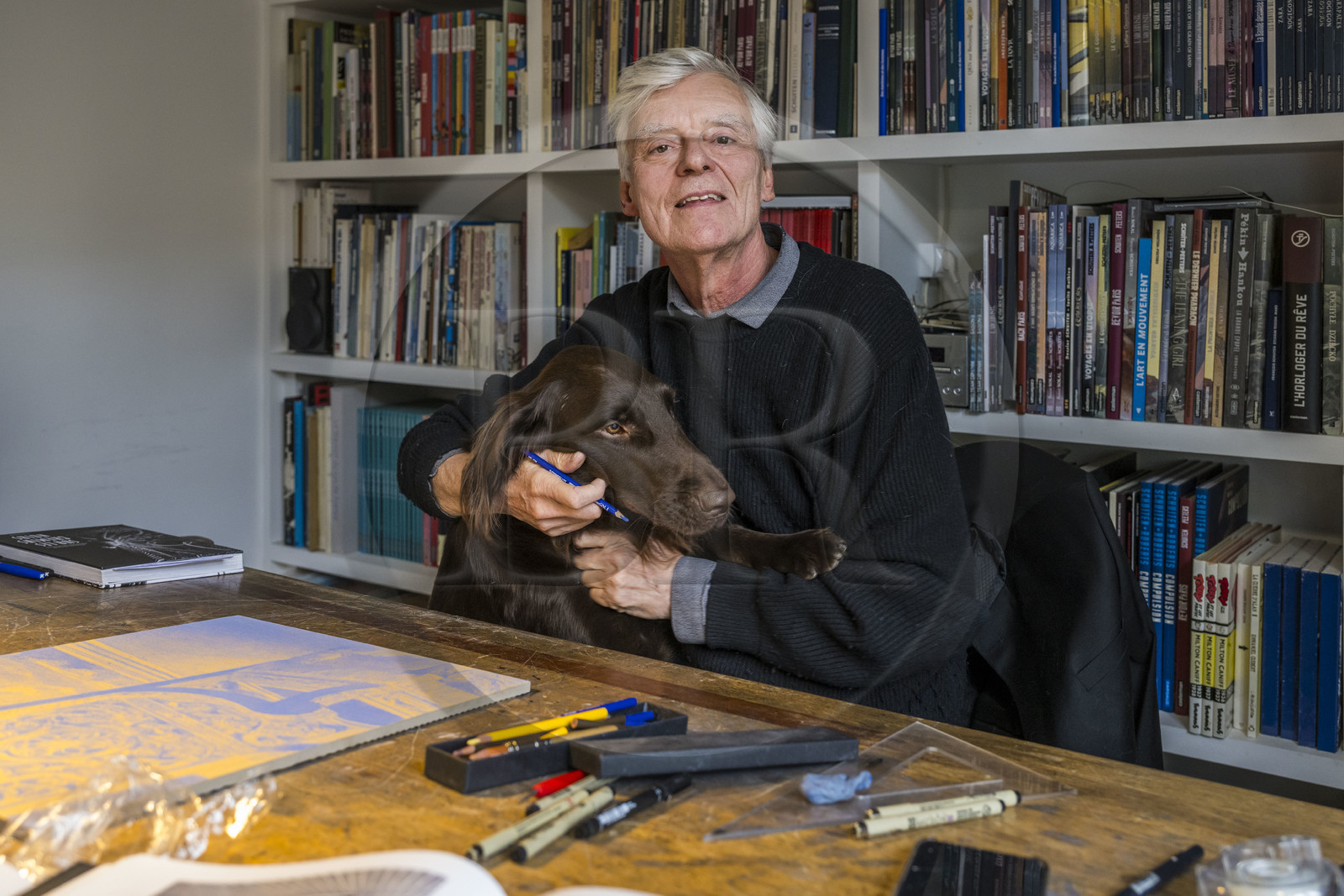 France, Paris, cartoonist and comic book author François Schuiten in his Parisian studio, with his dog Ulysses