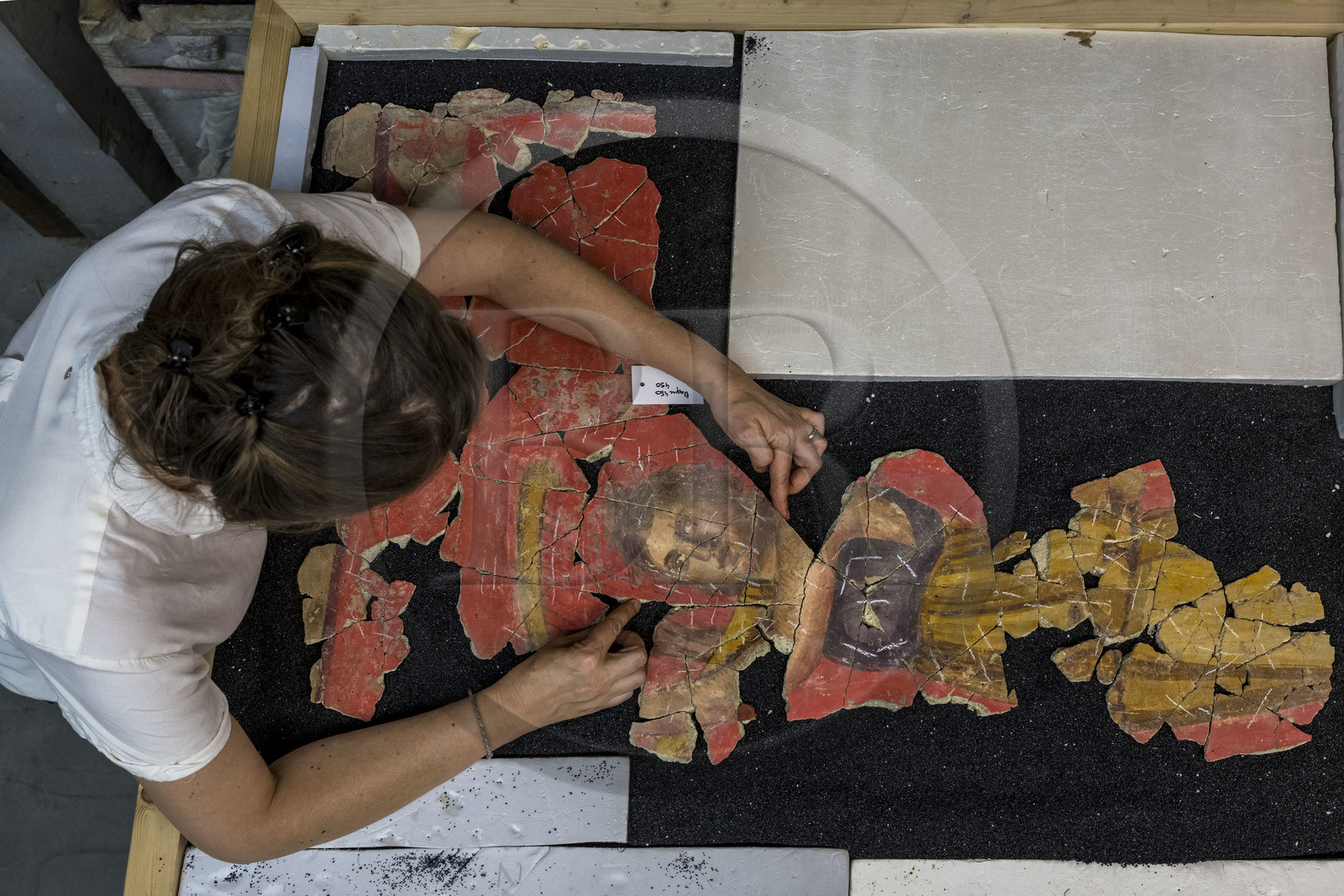 France, Bouches-du-Rhône (13), Arles, musée départemental Arles antique, dans les réserves du musée, issu des fouilles des ruines de la maison de la harpiste (entre 70 et 50 av. J.-C.) dans le site de l'ancienne verrerie de Trinquetaille sur la rive droite du Rhone, assemblage de fragments de la peinture murale à fresque adoptant du rouge vermillon avec le pigment le Cinabre le plus couteux du monde romain, la figure d’une harpiste qui a donnée son nom à la villa