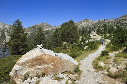 France, Hautes Pyrenees, Saint Lary Soulan and Vielle Aure, Neouvielle National Nature Reserve, Neouvielle lakes hike, hiker on a path between the lake of Aubert and the lake of Aumar