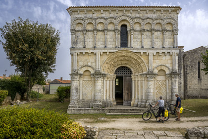France, Charente Maritime, Echillais, cyclists traveling along the cycle route in front of the 12th century Romanesque church of Notre-Dame, classified as a historic monument