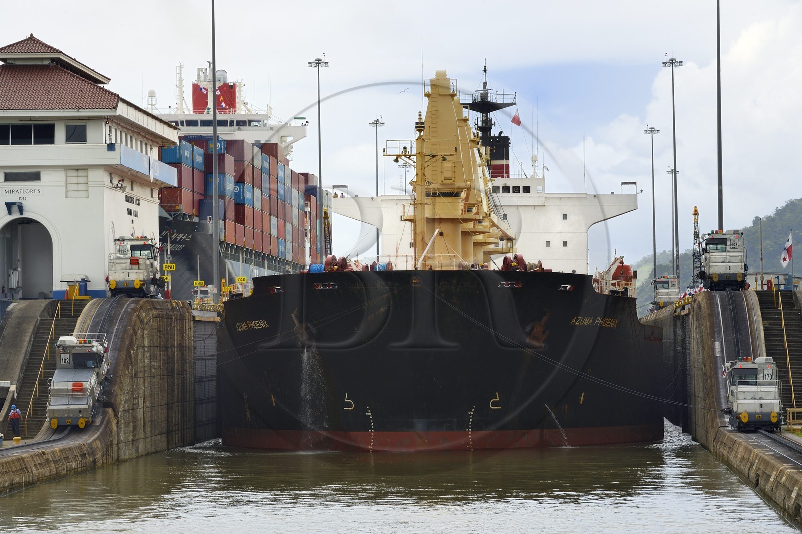 Panama, Canal de Panama, écluses de Miraflores, mules mécaniques ou locomotives électriques guidant un cargo Panamax entre les murs de l'écluse