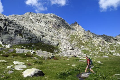 France, Alpes-Maritimes, parc national du Mercantour (Mercantour National Park), the Vallee des Merveilles (Valley of Wonders) scattered with thousands of rupestral engravings of the Bronze Age, Hiker at the base of the Cime des Lacs (2510m) mountain