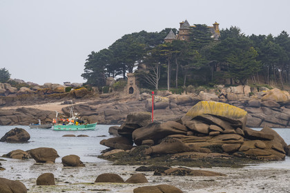 France, Côtes-d'Armor (22), Côte de Granit Rose, Perros-Guirec, bateau de pêche dans le chenal de sortie du port naturel de Ploumanac'h et le chateau de Costaérès sur son ile en arrière plan