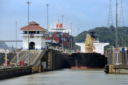 Panama, Canal de Panama, écluses de Pedro Miguel, mules mécaniques ou locomotives électriques guidant un cargo Panamax entre les murs de l'écluse