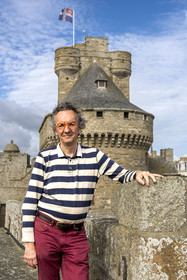 France, Ille et Vilaine, Cote d'Emeraude (Emerald Coast), Saint Malo, the Saint-Malo historian Olivier Chereil de la Rivière, owner of the Magon private mansion, an authentic 18th century corsair residence, the dungeon of the Saint-Malo castle (15th century) in the background