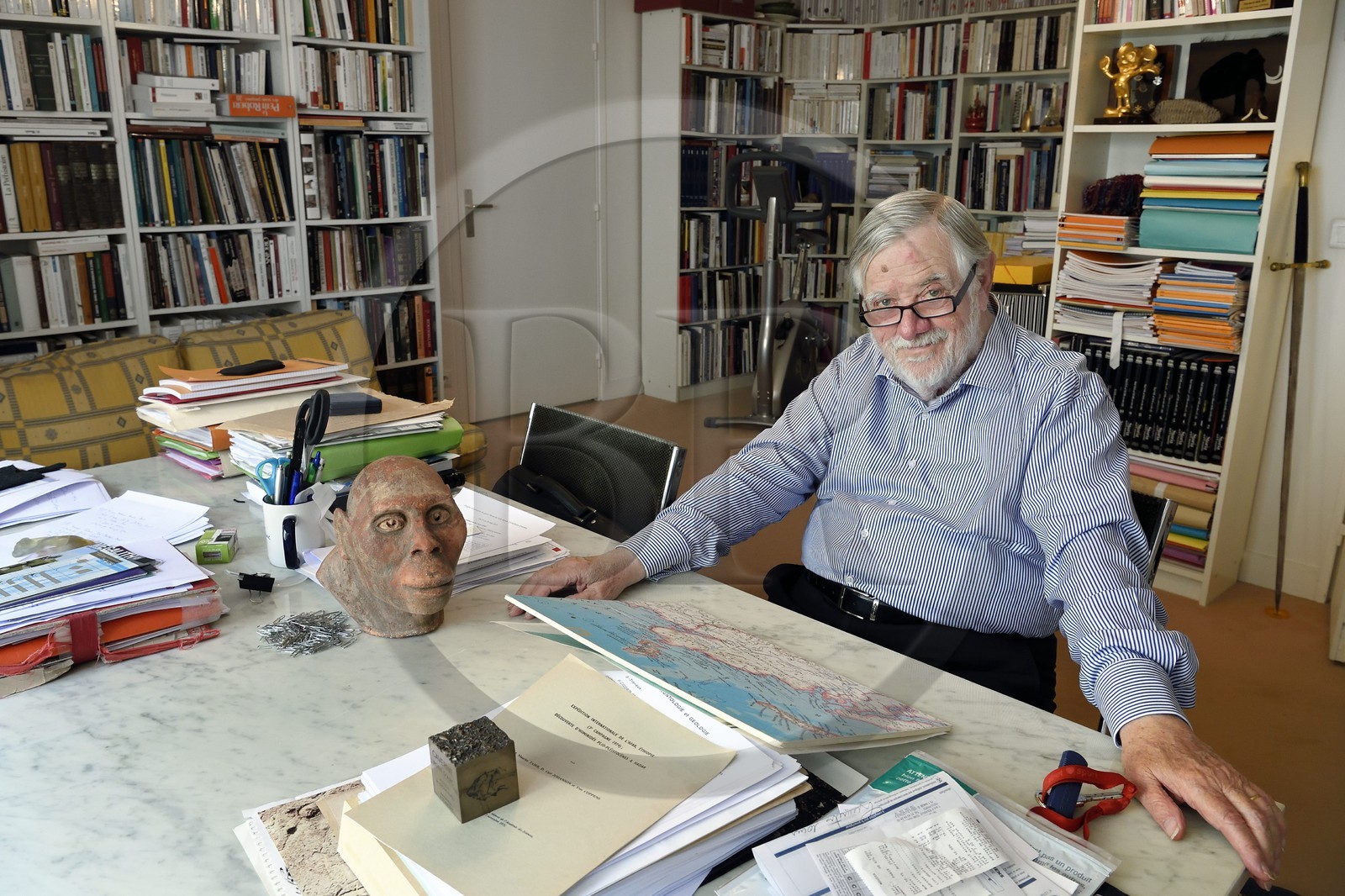 France, Paris, the french paleontologist and paleoanthropologist Yves Coppens, professor at the College de France, in the office of his home in Paris, with the supposed reproduction of Lucy's face
