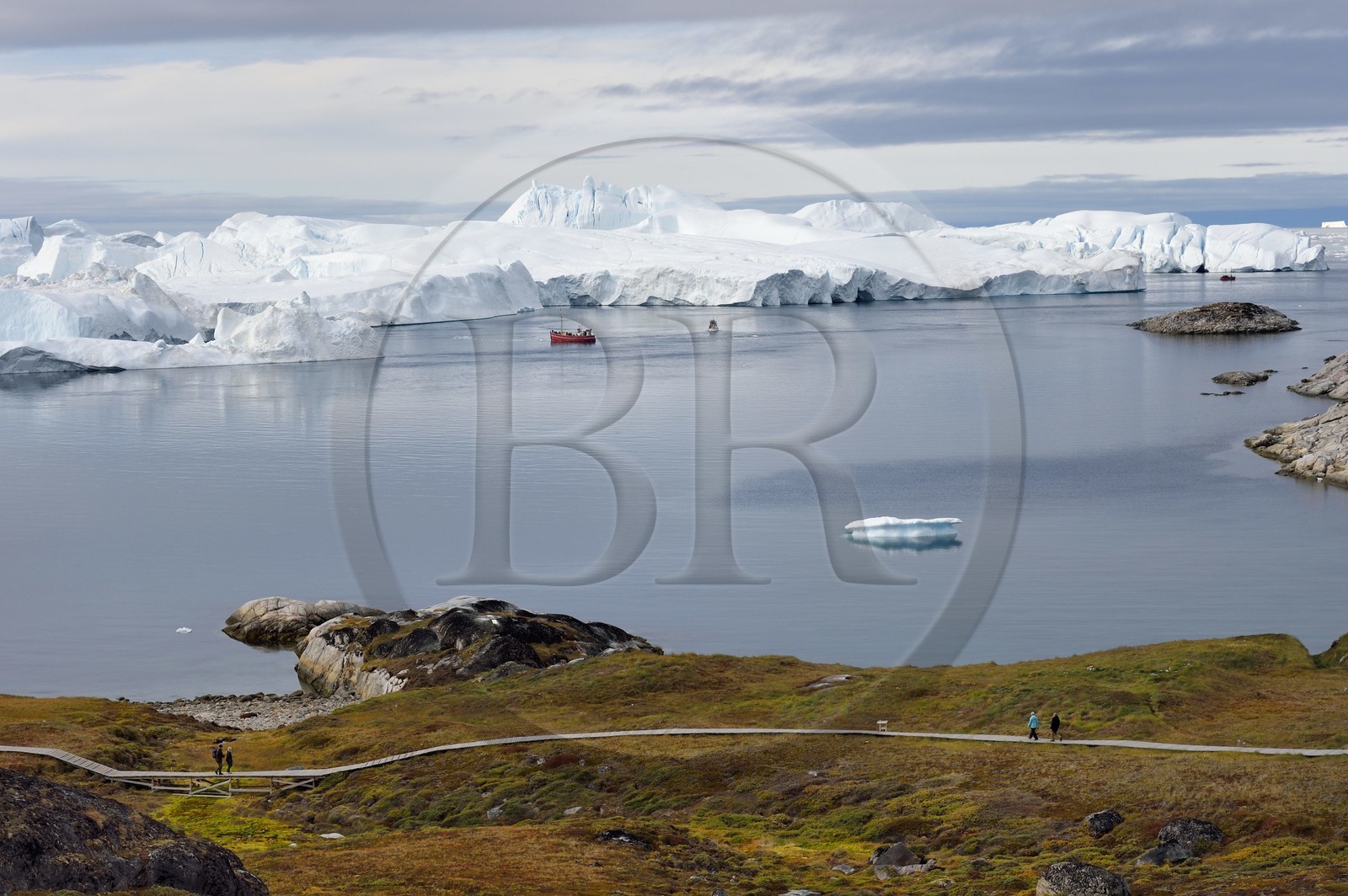Groenland, cote ouest, baie de Disko, Ilulissat, fjord glacé classé Patrimoine Mondial de l'UNESCO qui est l’embouchure maritime du glacier Sermeq Kujalleq (Jakobshavn Glacier), passerelle en bois du chemin de randonnée allant sur le site de Sermermiut et bateau de pêche au pied des icebergs