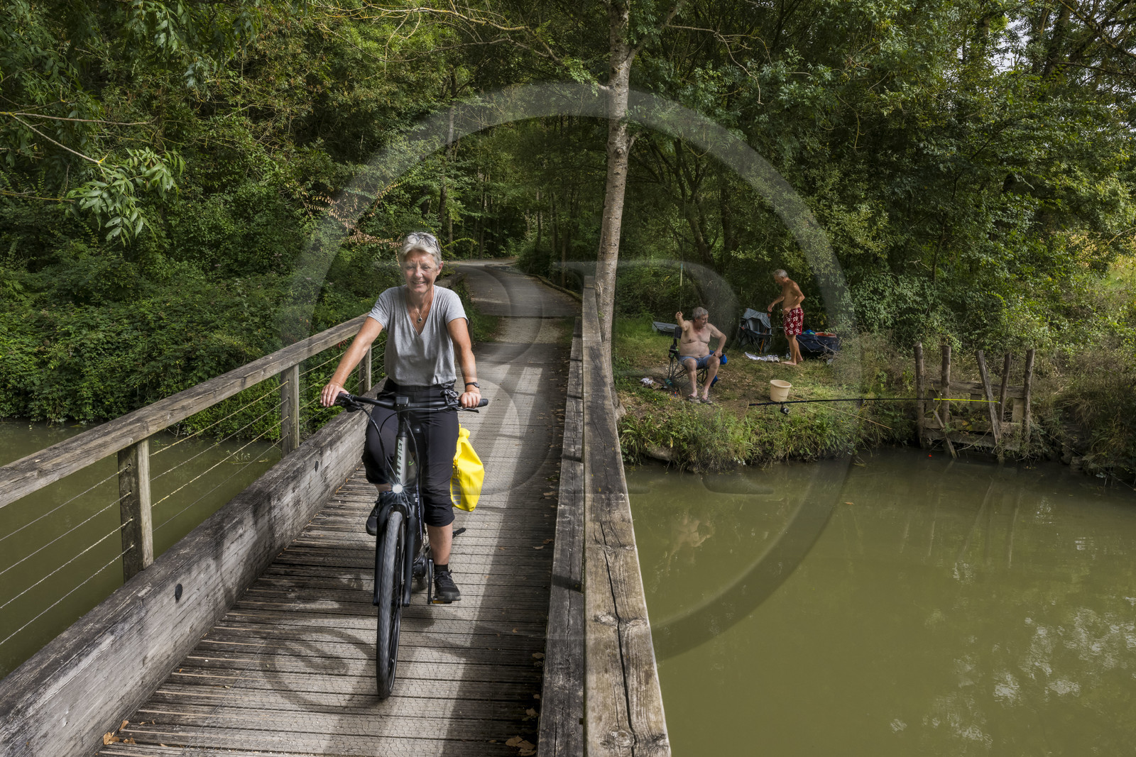 France, Charente-Maritime (17), Saint-Agnan, cycliste sur la véloroute en direction de l'abbaye de Trizay, rencontre avec des pêcheurs en bordure du petit canal de Pont-l'Abbé dans la vallée de l’Arnoult