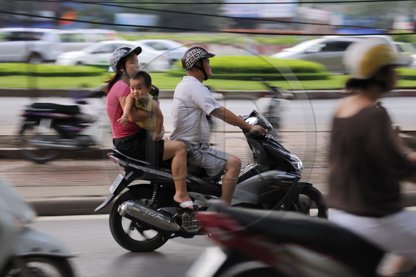 Vietnam, Hanoi, hazardous driving for a family on a motorbike