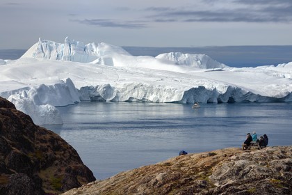 Greenland, west coast, Disko Bay, Ilulissat, icefjord listed as World heritage by UNESCO that is the mouth of the Sermeq Kujalleq Glacier (Jakobshavn Glacier), hike on the site of Sermermiut and fishing boat at the foot of icebergs
