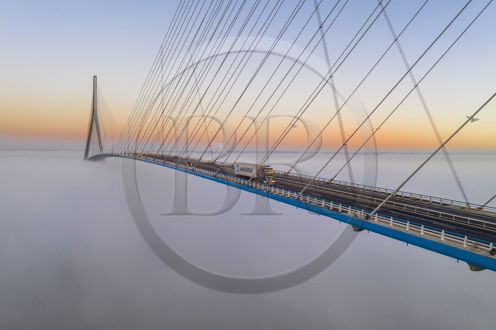 France, entre Calvados (14) et Seine-Maritime (76), le Pont de Normandie émerge des brumes matinales de l'automne et enjambe la Seine pour relier les villes de Honfleur et du Havre