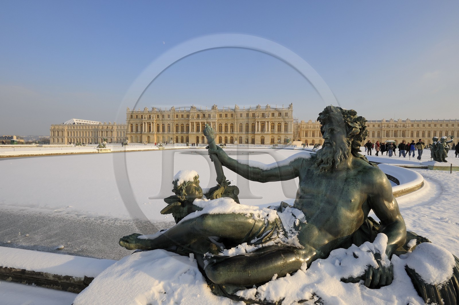 France, Yvelines, snow covered park of the Chateau de Versailles, listed as World Heritage by UNESCO, Parterre d'eau, statue showing a French river