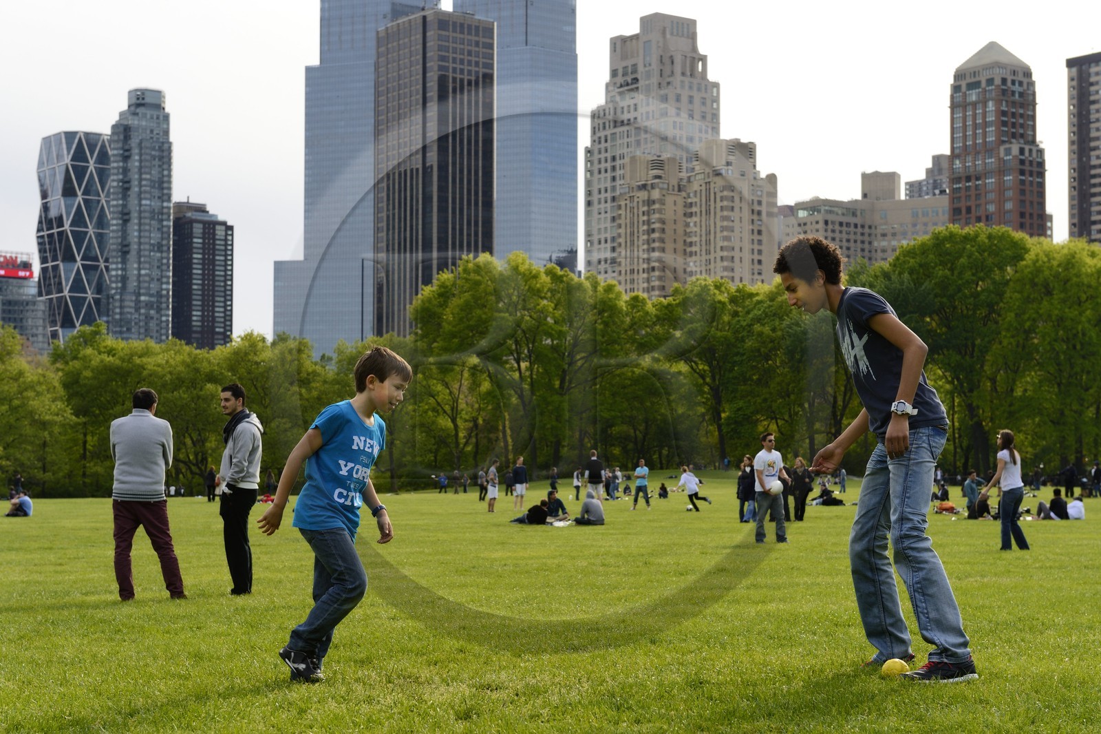 Etats-Unis, New York, Manhattan, Central Park, enfants jouant au football sur le Sheep Meadow, immeubles de Central Park Sud en arrière plan