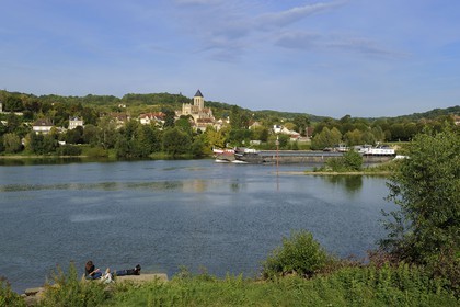 France, Val-d'Oise (95), une péniche descent la Seine devant le village de Vétheuil et son église Notre Dame peinte par Claude Monet