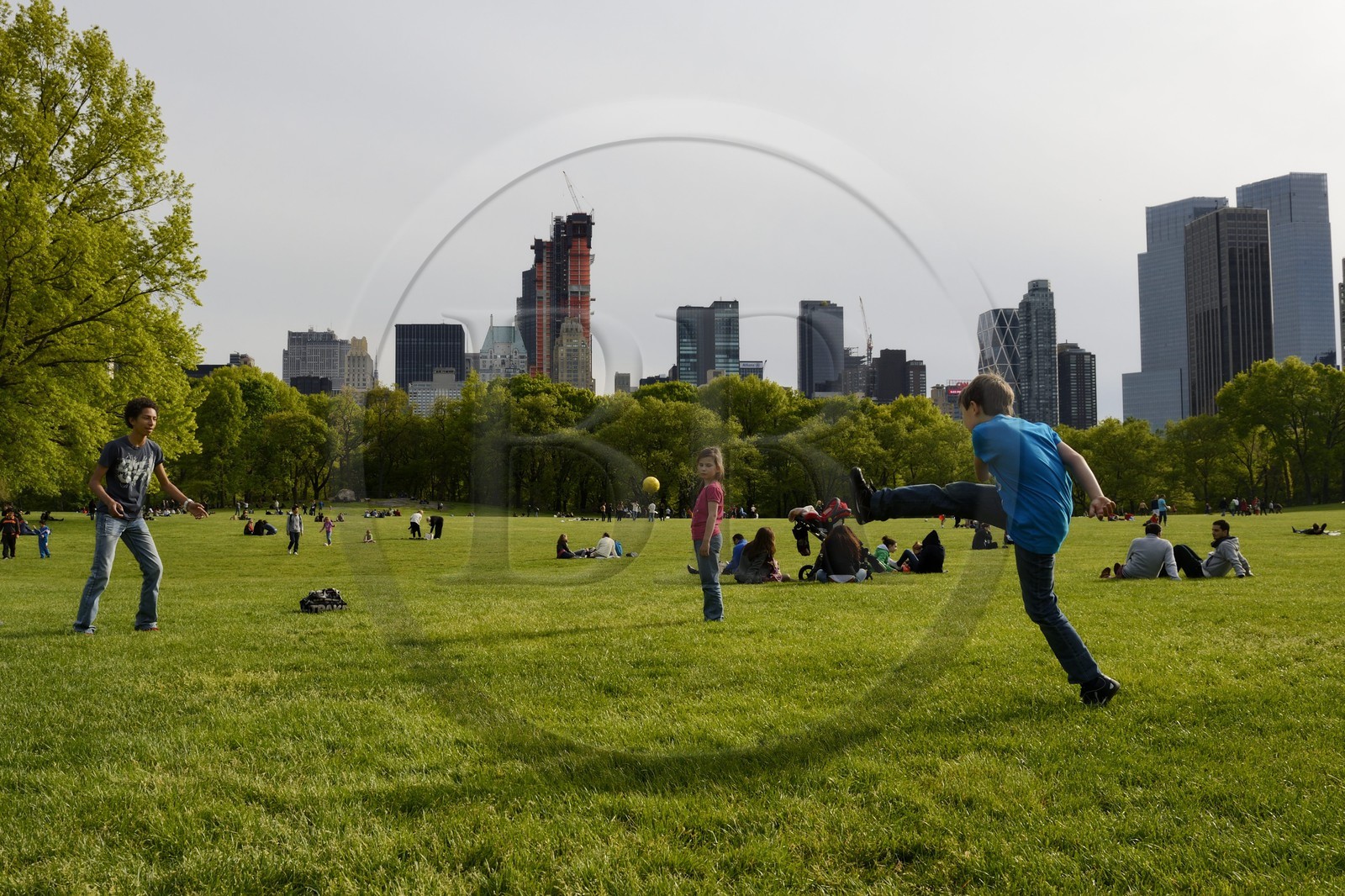 Etats-Unis, New York, Manhattan, Central Park, enfants jouant au football sur le Sheep Meadow, immeubles de Central Park Sud en arrière plan