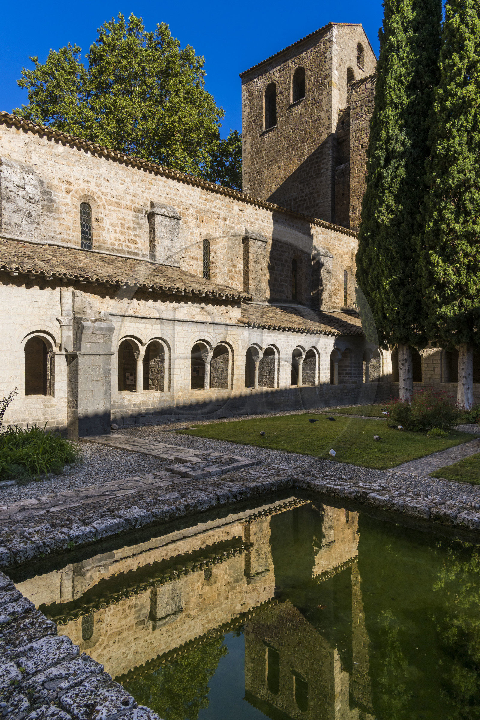 France, Hérault (34), Causses et les Cévennes, paysage culturel de l'agro-pastoralisme méditerranéen, classés Patrimoine Mondial de l'UNESCO, Saint-Guilhem-le-Désert, labellisé Les Plus Beaux Villages de France, l'abbaye de Gellone du IXème siècle, le cloitre avec son vivier au premier plan